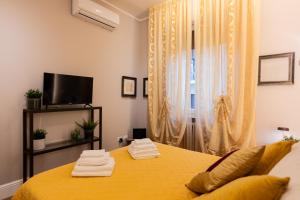 a bedroom with a yellow bed and a window at Smooth Mansion in Ponte Vecchio in Florence