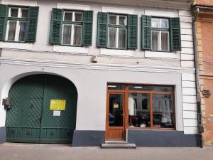 a building with a green door and windows at Apartament Anatol in Sibiu