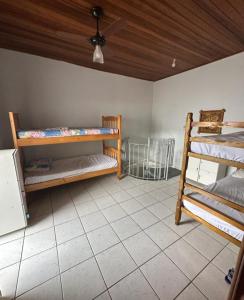a room with two bunk beds and a ceiling at Hostel Bike Point Caraguatatuba in Caraguatatuba