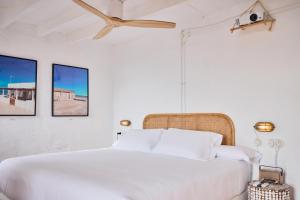 a bedroom with a white bed with two pictures on the wall at Cortijo La Loma in La Isleta del Moro