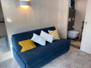 Un sofá azul con cuatro almohadas. en Auf Wolke 7 - Gäste-Studio im Mini House, en Aeschi