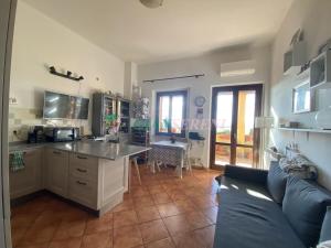 eine Küche und ein Wohnzimmer mit einem Sofa und einem Tisch in der Unterkunft Casegialle in La Sdriscia
