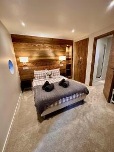 een slaapkamer met een groot bed en een houten muur bij Large central apartment for 10 by Avoriaz Chalets in Avoriaz