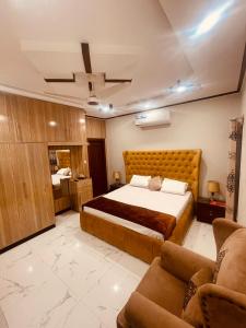 a bedroom with a large bed and a couch at Britannia House near Islamabad International Airport and Motorway in Islamabad