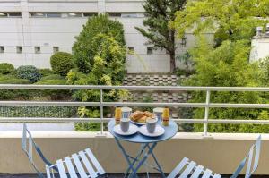 uma mesa com comida e duas cadeiras numa varanda em 322 Suite Fes - Superb apartment em Suresnes