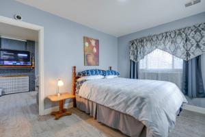 1 dormitorio con 1 cama, TV y ventana en Kalamazoo Vacation Rental Near Golf and Parks! en Kalamazoo