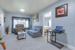 a living room with a couch and a laptop on a table at Kalamazoo Vacation Rental Near Golf and Parks! in Kalamazoo