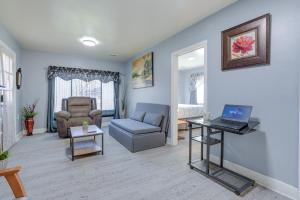 uma sala de estar com um sofá e um computador portátil sobre uma mesa em Kalamazoo Vacation Rental Near Golf and Parks! em Kalamazoo