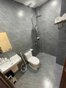 y baño con aseo, lavabo y ducha. en Rio Guest House - Phú Quốc en Phu Quoc