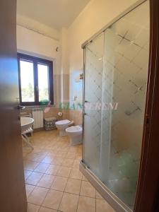 ein Bad mit einer Glasdusche und einem WC in der Unterkunft Casegialle in La Sdriscia