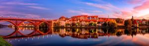 a bridge over a body of water with a city at Hotel Arena Maribor in Maribor