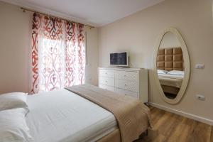 1 dormitorio con 1 cama grande y espejo en The Urban Villa en Shkodër