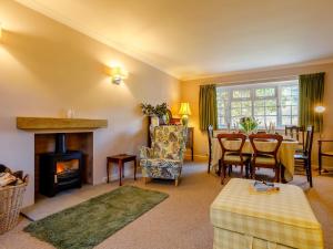 a living room with a fireplace and a table and chairs at 3 Bed in Branscombe 78002 in Branscombe