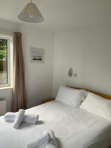 a bedroom with a white bed with towels on it at St Merryn in Carbis Bay