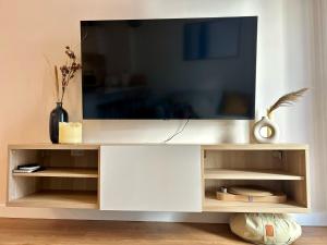 a white entertainment center with a tv on top at Apartamento Boutique - Palm City Centro in Elche