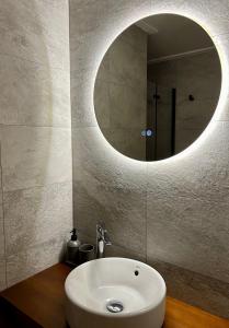 uma casa de banho com um lavatório branco e um espelho. em Sol Mediterráneo Palm City em Elche