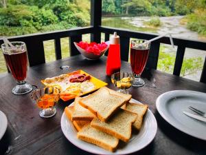 a wooden table with sandwiches and glasses of wine at The Magical Tree House in Yatiyantota