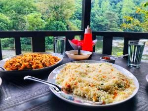 a wooden table with two plates of food on it at The Magical Tree House in Yatiyantota