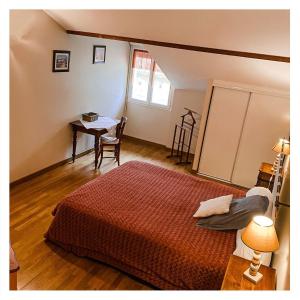 a bedroom with a bed and a table and a desk at Domaine Hias in Angoumé