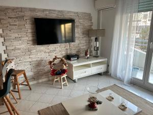 a living room with a tv on a brick wall at LaMer in Juan-les-Pins