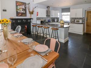 a kitchen with a wooden table with chairs and a counter at The Vines in Bridgend