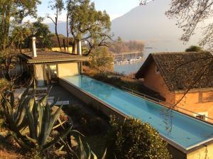 une maison avec une piscine à côté d'un bâtiment dans l'établissement Villa Mappina Roccabella, à Locarno