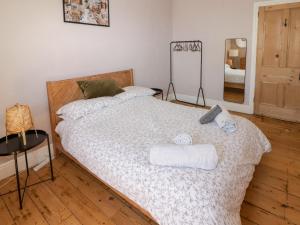 a bedroom with two beds with towels and a mirror at The Vines in Bridgend
