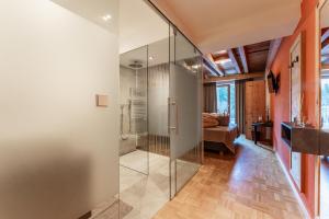 Una ducha de cristal en una habitación con dormitorio en Hotel Restaurant Seehaus Mountain Lake Resort en San Giuseppe in Anterselva
