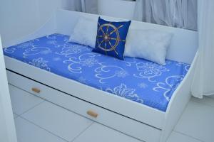 a bed with a blue comforter and a clock on it at Kensington Square Luxury Apartment in Flic-en-Flac +10 photos