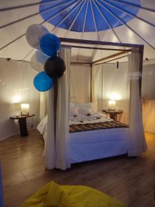 1 dormitorio con 1 cama con globos azules y blancos en Chigüa Glamping, en Ráquira