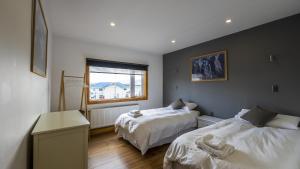 a bedroom with two beds and a window at Hostel Belator Experience in Puerto Natales