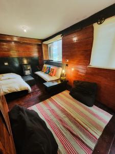 een slaapkamer met een bed, een bank en een tapijt bij Wolf Totem Industrial Chic Studio in Pisac