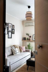 uma sala de estar com um sofá e uma mesa em Pomegranate , Luxury Penthouse Maisonette with Beautiful Terrace by BiNoBi ! em Tessalônica