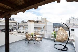 a balcony with chairs and a table on a roof at Pomegranate Luxury Penthouse Maisonette with Stunning Terrace #Free Parking# by BiNoBi! in Thessaloniki