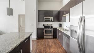 una cucina con elettrodomestici in acciaio inossidabile e armadietti neri di Landing - Modern Apartment with Amazing Amenities (ID2269) a Franklin