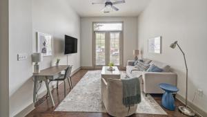 een woonkamer met een bank, een tafel en een bureau bij Landing - Modern Apartment with Amazing Amenities (ID2269) in Franklin