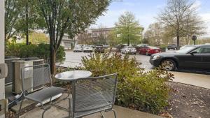 een tafel en stoelen op een stoep naast een parkeerplaats bij Landing - Modern Apartment with Amazing Amenities (ID2269) in Franklin