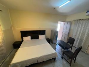 トゥバブ・ディアラオにあるChez Mimiのベッドルーム1室(大型ベッド1台、椅子2脚付)
