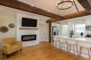a kitchen with a fireplace and a tv on the wall at Cape Henry House Inn at Old Beach in Virginia Beach +31 photos