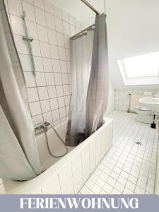 a bathroom with a shower and a tub and a sink at Hotel Lamm in Pforzheim