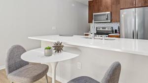 cocina blanca con mesa y sillas en Landing - Modern Apartment with Amazing Amenities (ID8458X97), en Saint Paul