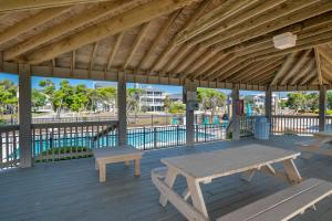 a wooden pavilion with a picnic table and benches on a deck at Ocean Dunes 0903 in Kure Beach