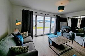 a living room with a couch and a table at Shoreside Villa - immaculate waterfront property in Skelmorlie in Skelmorlie