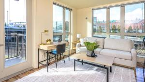 a living room with a couch and a table and windows at Landing - Modern Apartment with Amazing Amenities (ID8687X92) in Tacoma