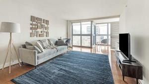 sala de estar con sofá y TV de pantalla plana en Landing - Modern Apartment with Amazing Amenities (ID1316X116), en Bethesda