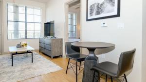 een woonkamer met een tafel en stoelen in een kamer bij Landing - Modern Apartment with Amazing Amenities (ID8201X09) in Orlando