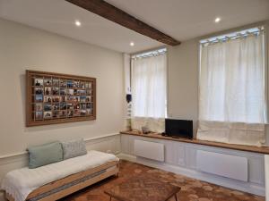Una sala de estar con un sofá y un televisor y una ventana. en Jardin de la Préfecture, en Arras