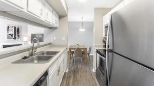 La cuisine est équipée d'un évier et d'un réfrigérateur en acier inoxydable. dans l'établissement Landing - Modern Apartment with Amazing Amenities (ID8404X94), à Cordova