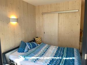 een slaapkamer met een bed met blauwe en witte lakens bij Auf Wolke 7 - Gäste-Studio im Mini House in Aeschi