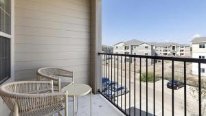 a balcony with two chairs and a view of condos at Landing - Modern Apartment with Amazing Amenities (ID1215X775) in Burleson